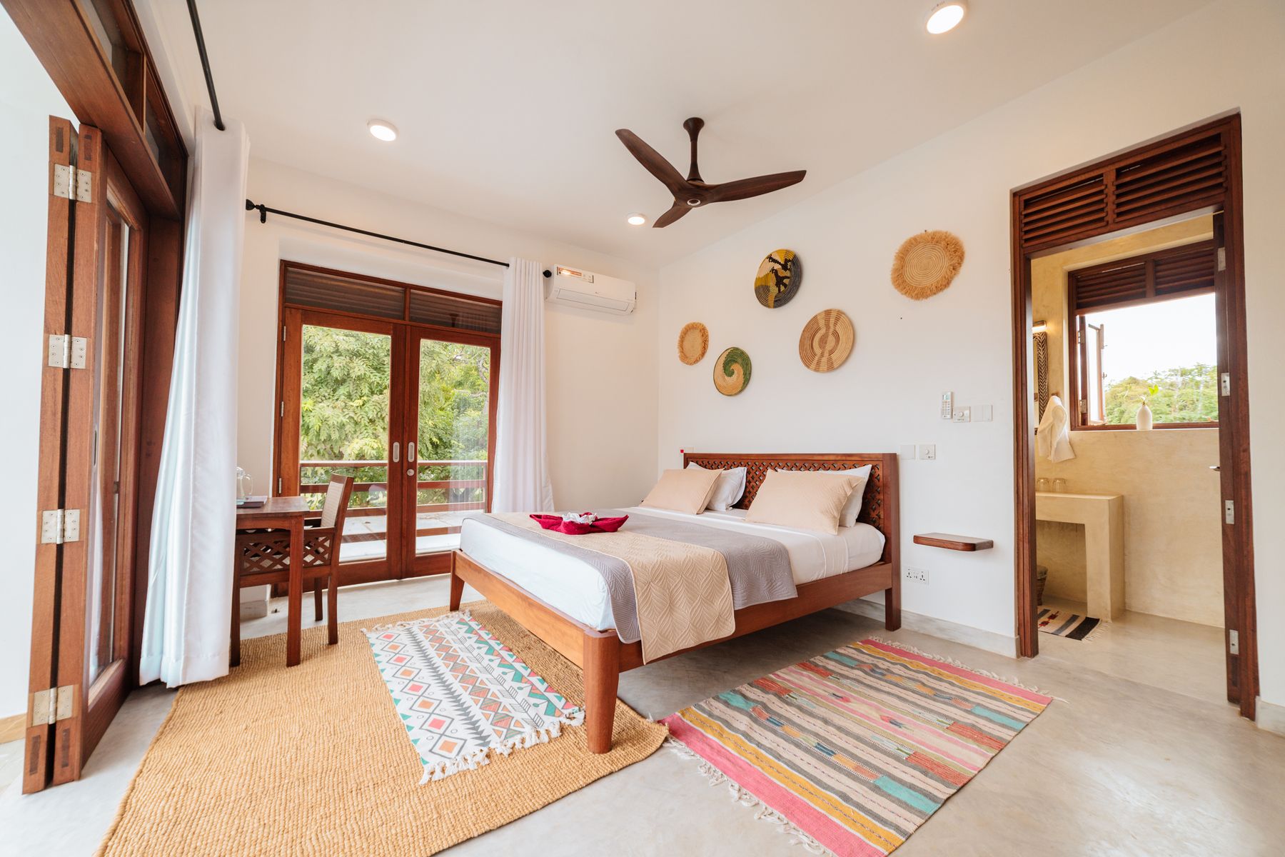 King bedroom with woven wall baskets and colourful rugs